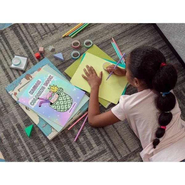 little girl coloring next to a kawaii coloring book